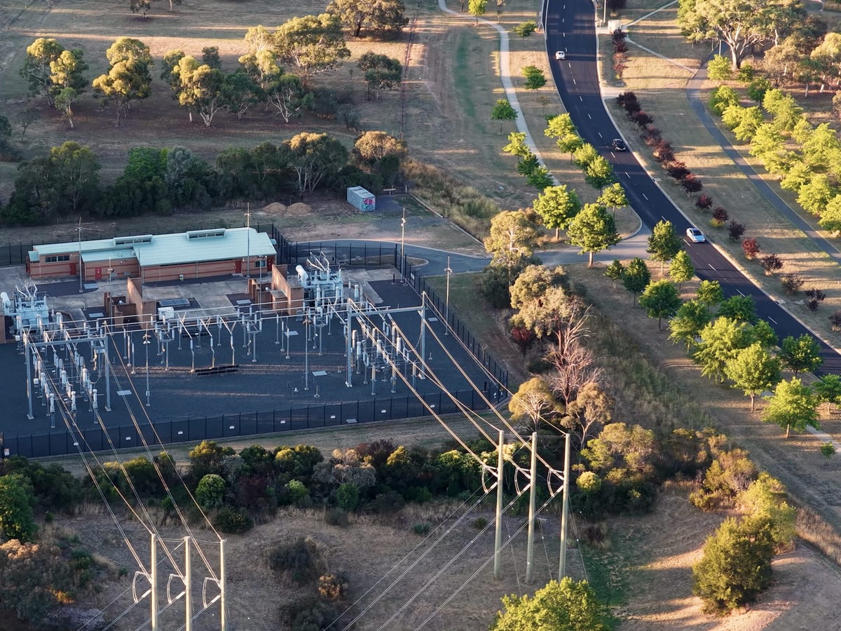Vue aérienne d'un poste électrique haute tension et de ses lignes de distribution.
